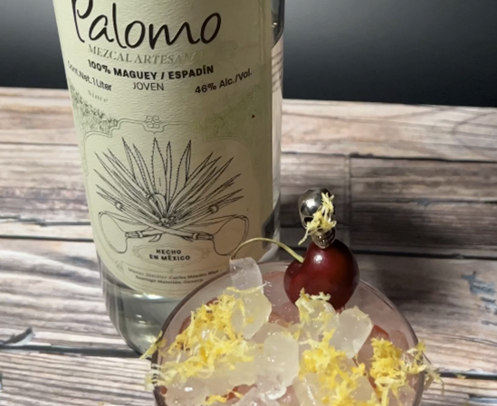 Palomo bottle with glass in front with garnish